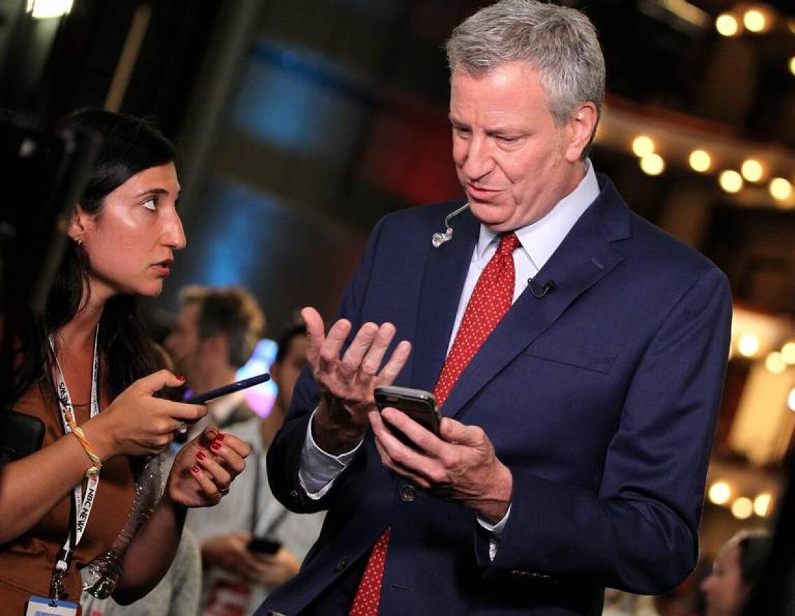 Democratic presidential candidate Bill de Blasio, mayor of New York City, talks to a campaign staff member as he gets ready for an interview on CNN in the spin room on the second day of the NBC Democratic Presidential Primary Debates for the 2020 election